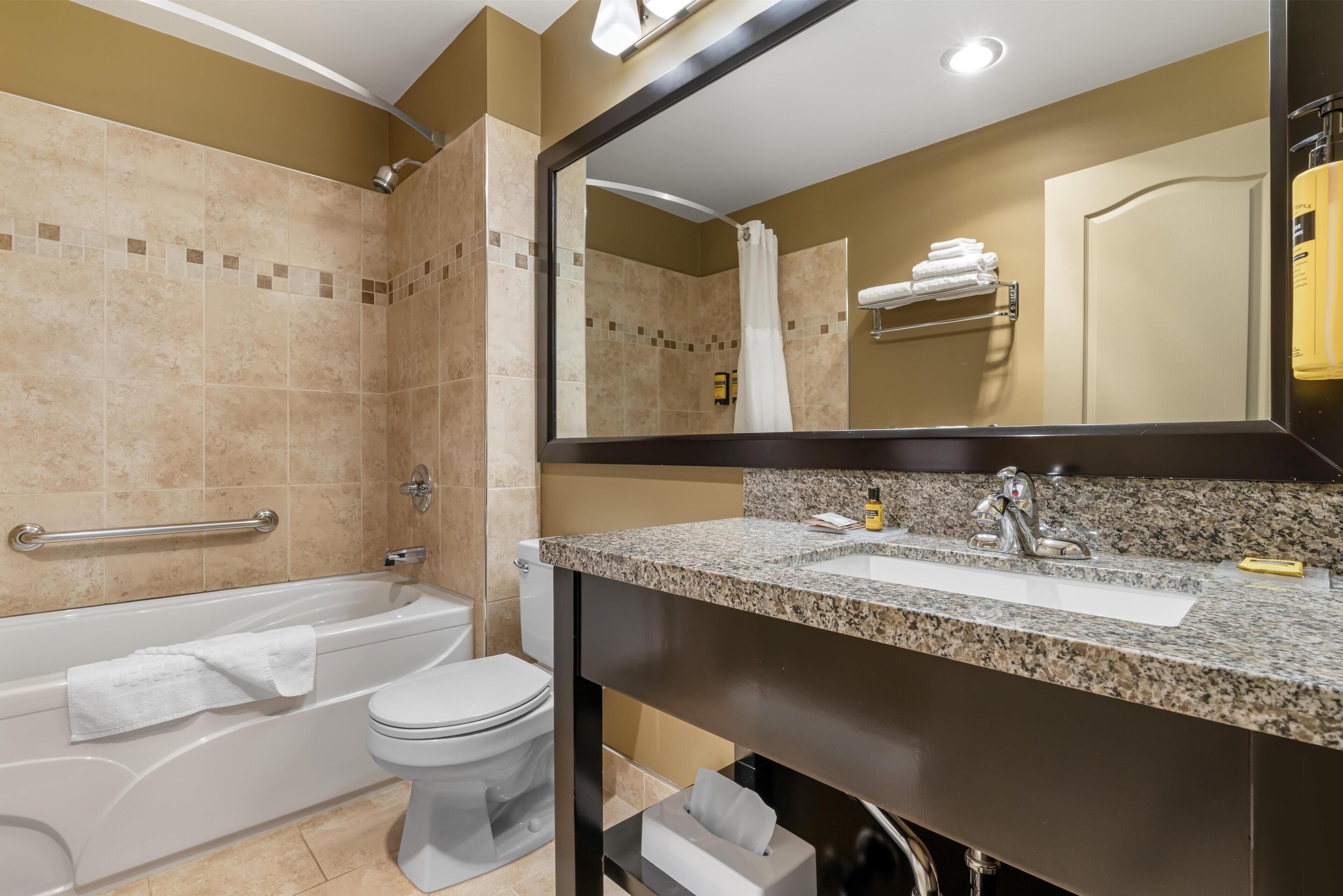 A modern bathroom with a bathtub, toilet, and sink.