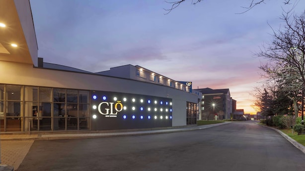 Un edificio moderno con un gran letrero iluminado que dice "GLO BEST WESTERN".