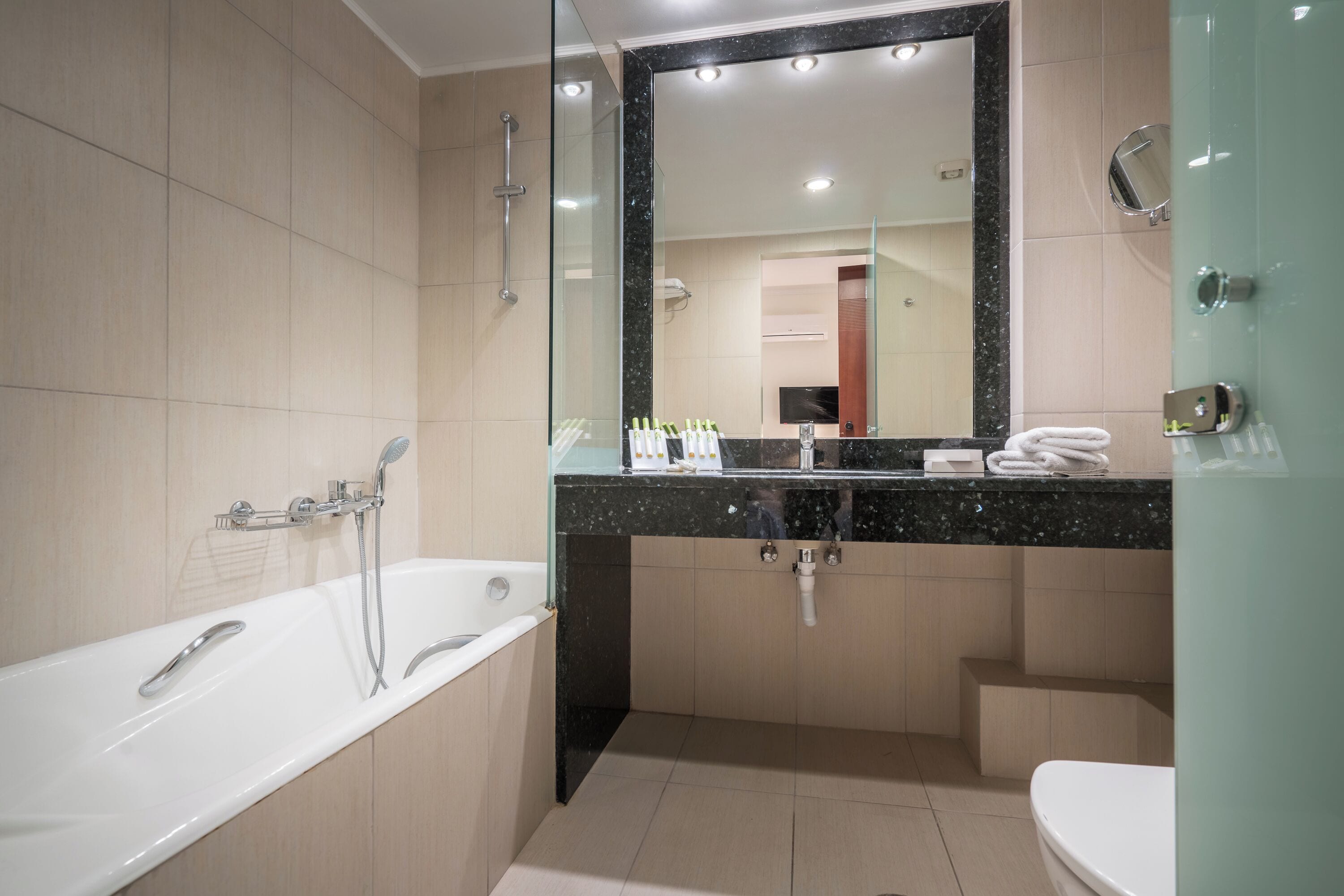 A modern bathroom with a bathtub, a sink, and a toilet.