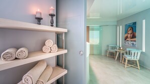 A modern spa room with shelves holding rolled towels, a door leading to another area, and a poster on the wall. - Zante Park Resort & Spa, BW Premier Collection (Zakynthos)