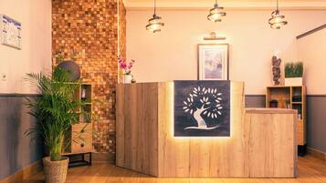 A reception area with a wooden reception desk, a wall-mounted clock, and a framed picture above the desk.