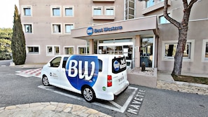 Welcome to Best Western, where guests can enjoy a convenient hotel entrance with a glass door and a tree nearby.