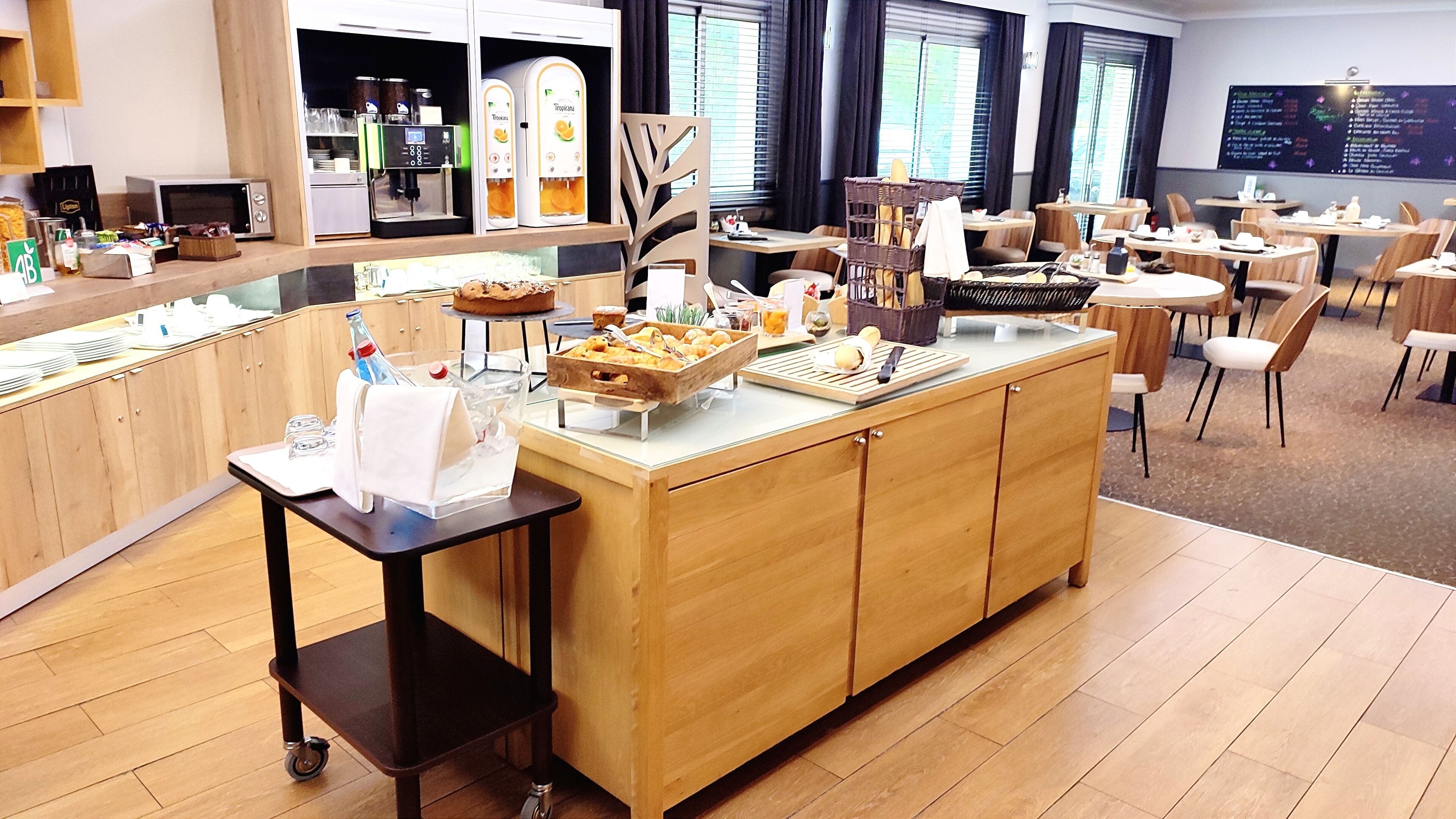 A buffet area with a variety of food items, a coffee machine, and a menu board.