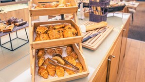Une vitrine de boulangerie présentant diverses pâtisseries et différents types de pain.