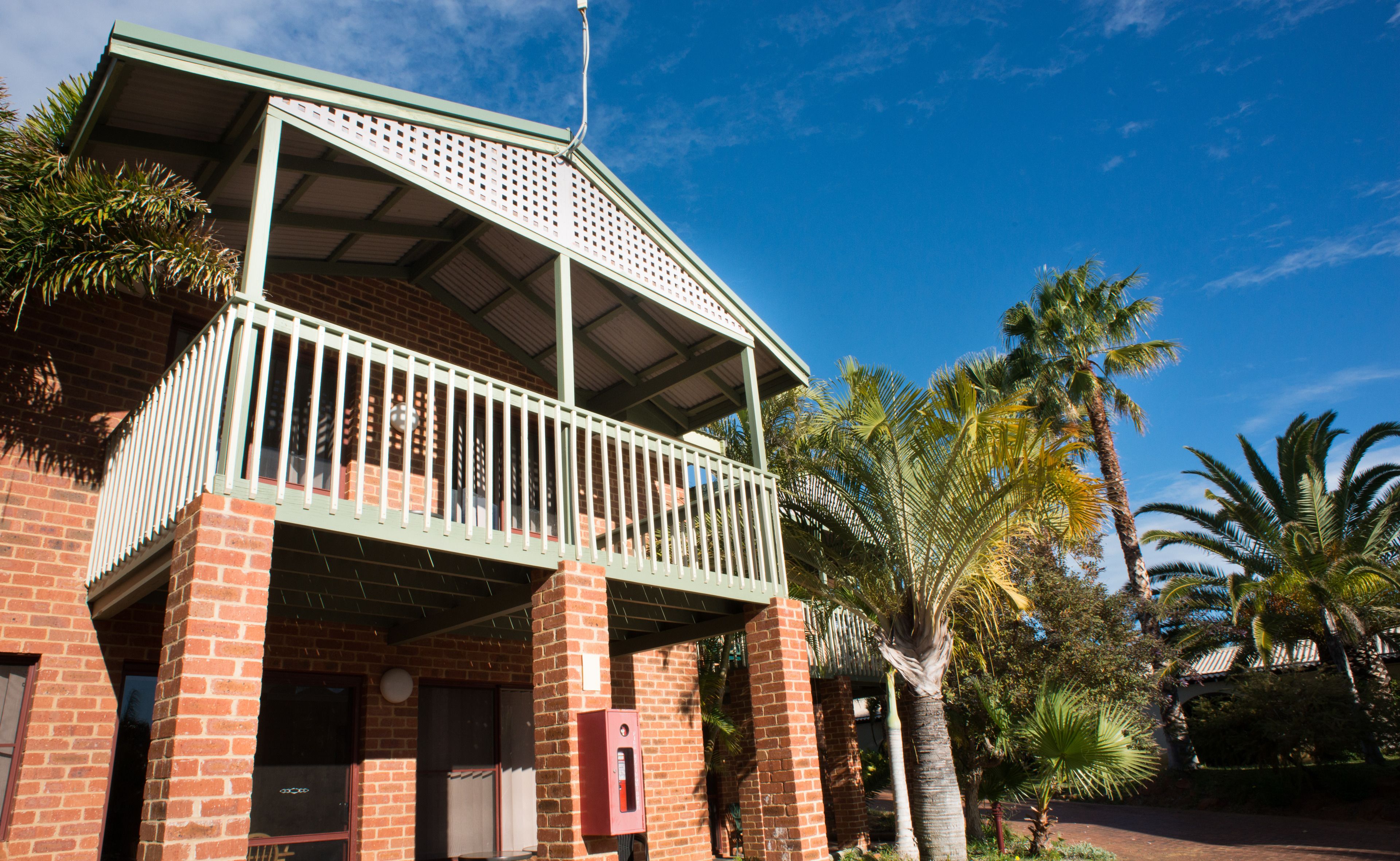 A two-story building with a balcony and a brick facade.