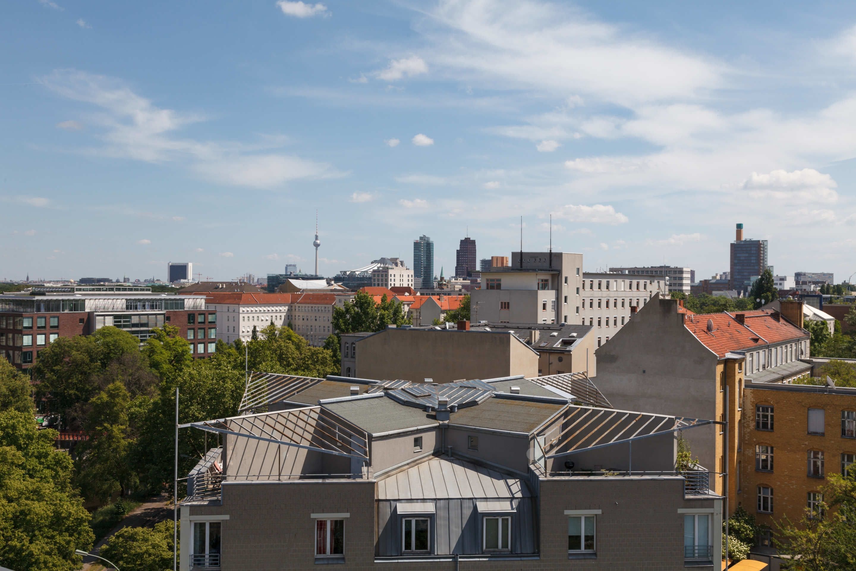 A cityscape with various buildings, including a prominent tower and several residential structures with distinct architectural styles.