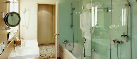 Un baño moderno con ducha envuelta en vidrio, lavamanos doble y bañera.