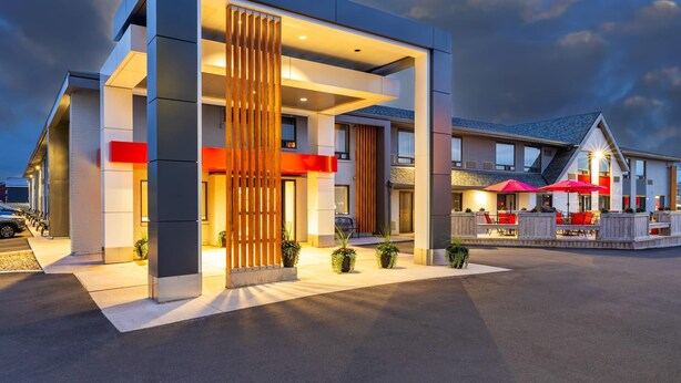 A modern hotel with a spacious outdoor area, a covered seating area, and a well-lit entrance. - Comfort Inn Charlottetown (Charlottetown)
