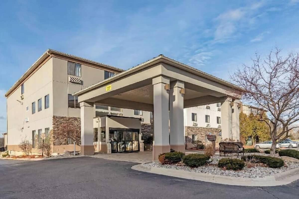 Un hôtel doté d’une entrée abritée, de nombreuses fenêtres et d’une façade en pierre.