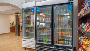 Un expositor refrigerado con diversas bebidas y aperitivos.