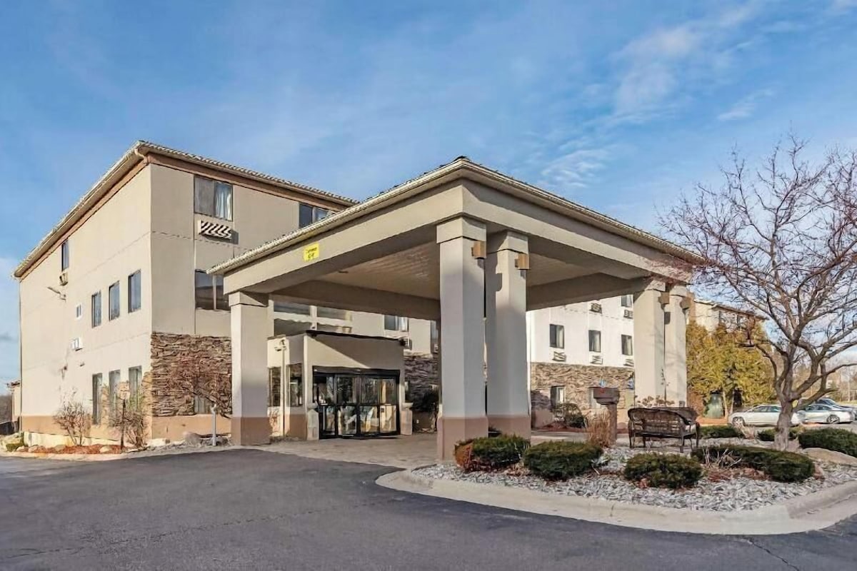 A hotel with a covered entrance, multiple windows, and a stone facade.