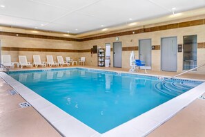 Een binnenzwembad, ligstoelen bij het zwembad