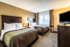 A hotel room with two beds, a TV, a desk, and a window with curtains. - Comfort Inn Detroit Downtown (Detroit)