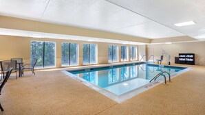 Una piscina interior con ventanales amplios, un espacio de descanso junto a la piscina y una estación de socorristas.