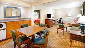 A hotel room with a dining area, a living room, a kitchen with a microwave, and a television. - Country Inn & Suites by Radisson, York, PA (York)