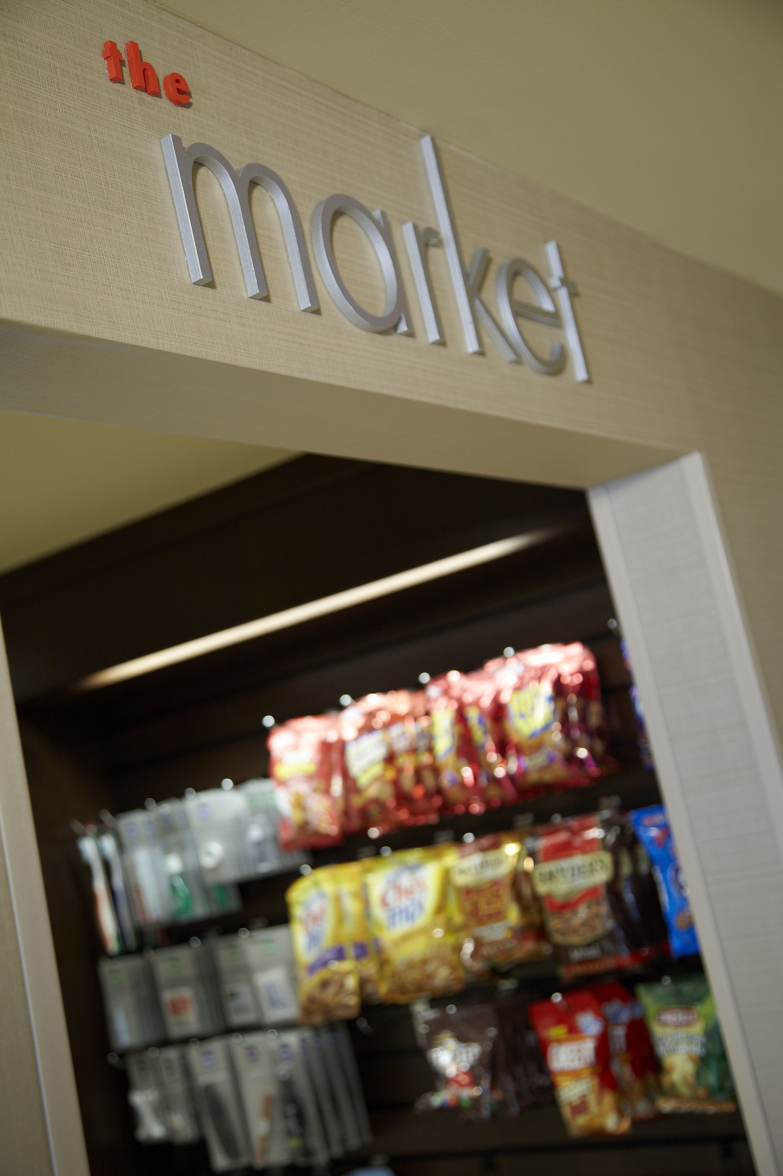 A store sign with the word "the market" and shelves stocked with various packaged goods.