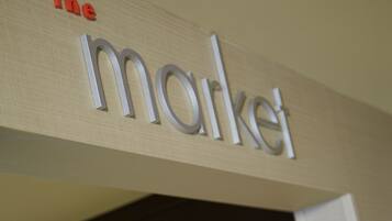 A store sign with the word "the market" and shelves stocked with various packaged goods.