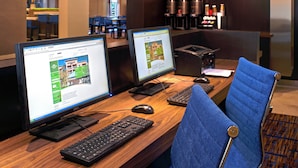 A hotel reception desk with two computer monitors, a keyboard, a mouse, and a blue chair. - Courtyard by Marriott Cleveland Independence (Independence)
