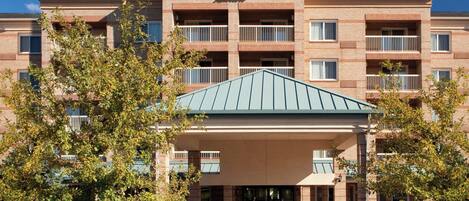 A Courtyard Marriott hotel with a brick facade, multiple balconies, and a covered entrance.