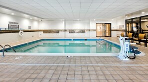 An indoor swimming pool with a tiled floor, a lifeguard chair, and a no diving sign. - Courtyard by Marriott Ballantyne (Charlotte)