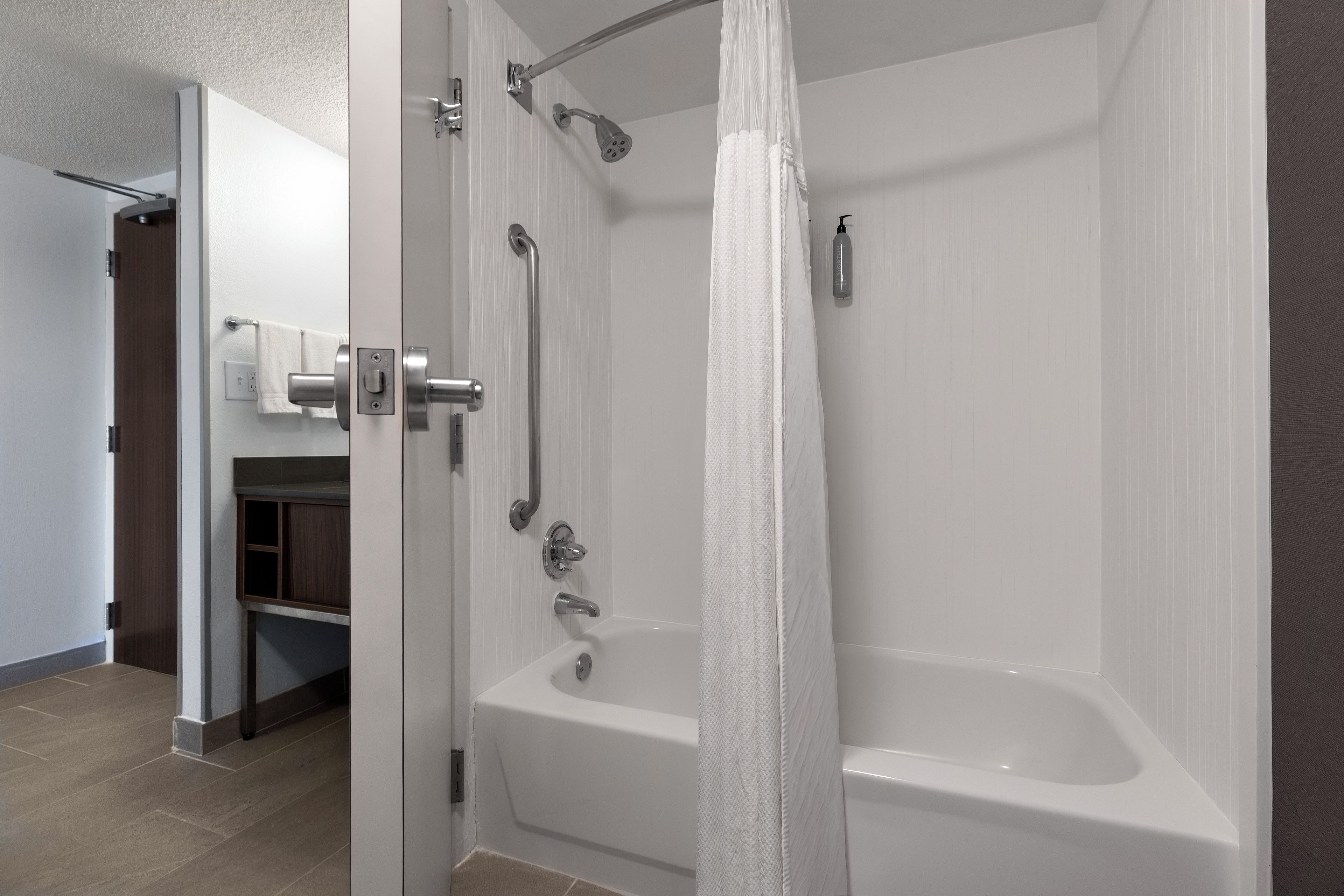 A modern bathroom with a walk-in shower, a bathtub, and a toilet.