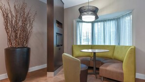 Een modern interieur met een bank, een salontafel, een potplant en een televisie.