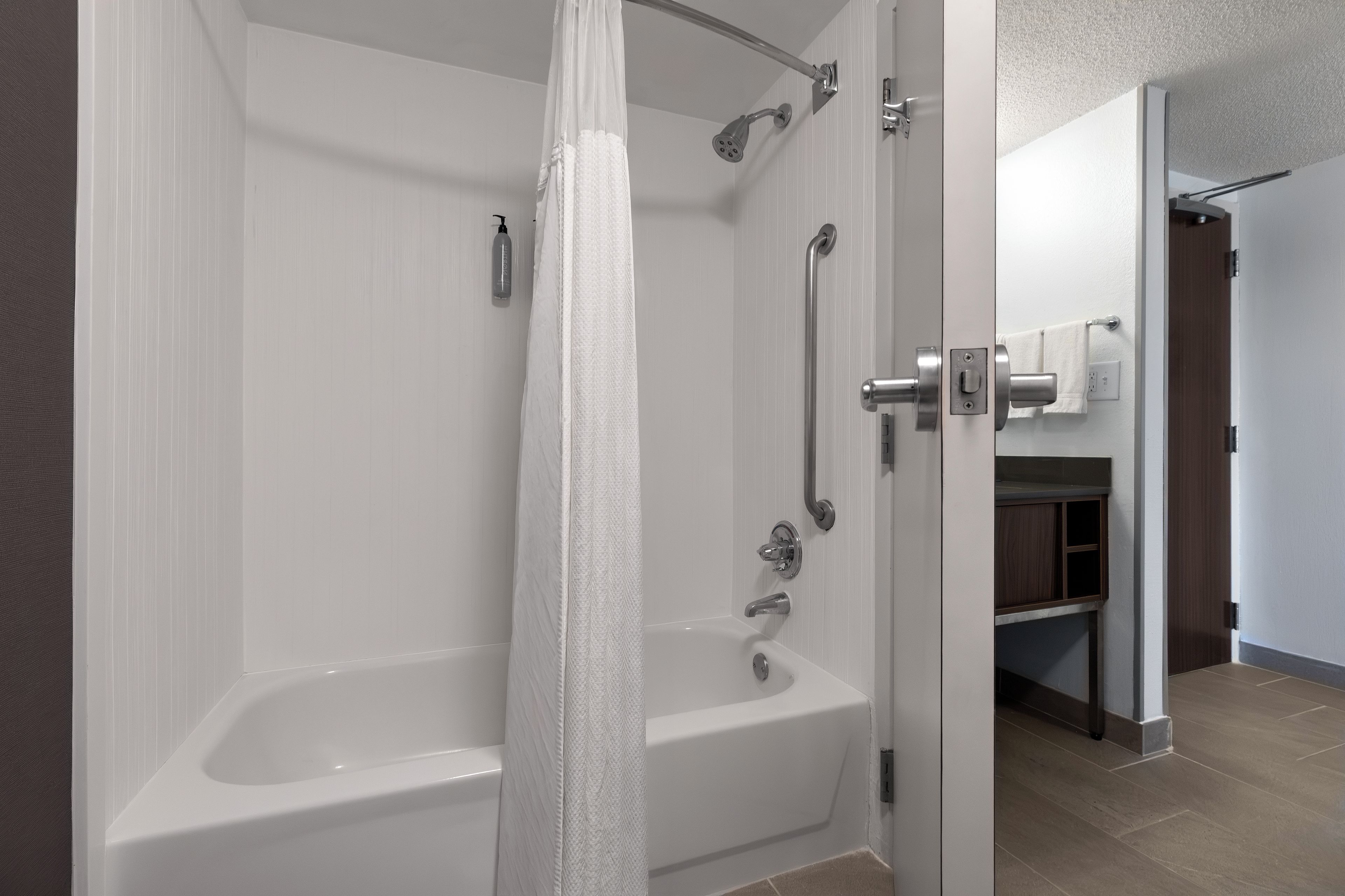 Een moderne badkamer met een inloopdouche, een badkuip en een toilet.