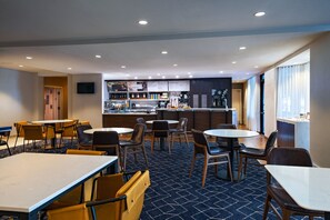 Relax in our welcoming lobby, featuring a central bar area with a variety of beverages and food options.