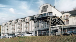 Un hotel a più piani con un evidente cartello 'PENTA HOTEL', caratterizzato da balconi e un ingresso coperto.