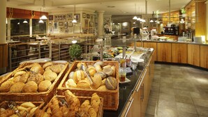 A buffet area with various food items and baskets of bread. - Courtyard by Marriott Hannover Maschsee (Hannover)