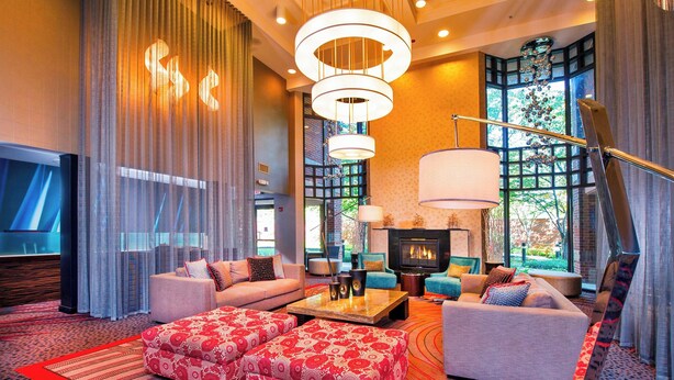 Una sala de estar moderna con chimenea, asientos cómodos y ventanas grandes.