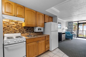 A spacious indoor area with seating arrangements, potted plants, and a visible door. at Grande Shores Ocean Resort
