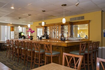 A lobby with a reception desk, two armchairs, a coffee table, a television, and DVD rental kiosks. at Grande Shores Ocean Resort