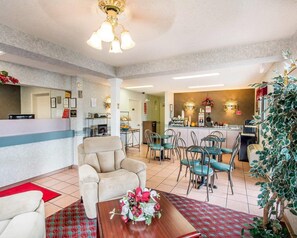 Eine Hotelhalle mit Rezeption, Sitzgelegenheiten und einer Küchenzeile.
