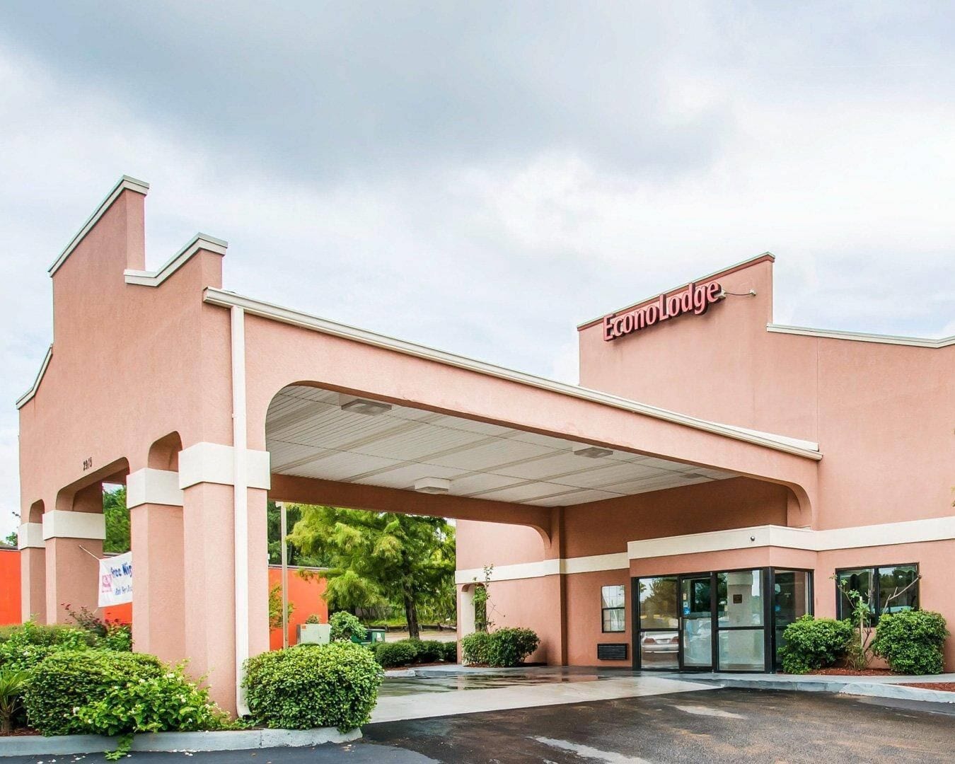 A hotel with a covered entrance, a sign reading 'Econo Lodge,' and a parking lot.