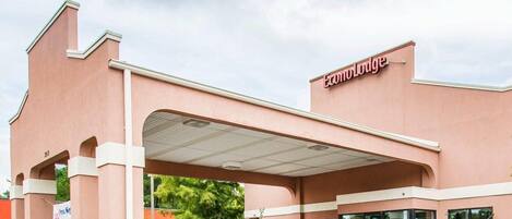 A hotel with a covered entrance, a sign reading 'Econo Lodge,' and a parking lot.