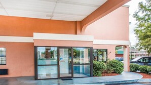 A building with a glass entrance, a concrete floor, and a parking lot. - Econo Lodge Dothan West (Dothan)