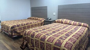 Quarto de hotel com duas camas, cada uma com colcha estampada.