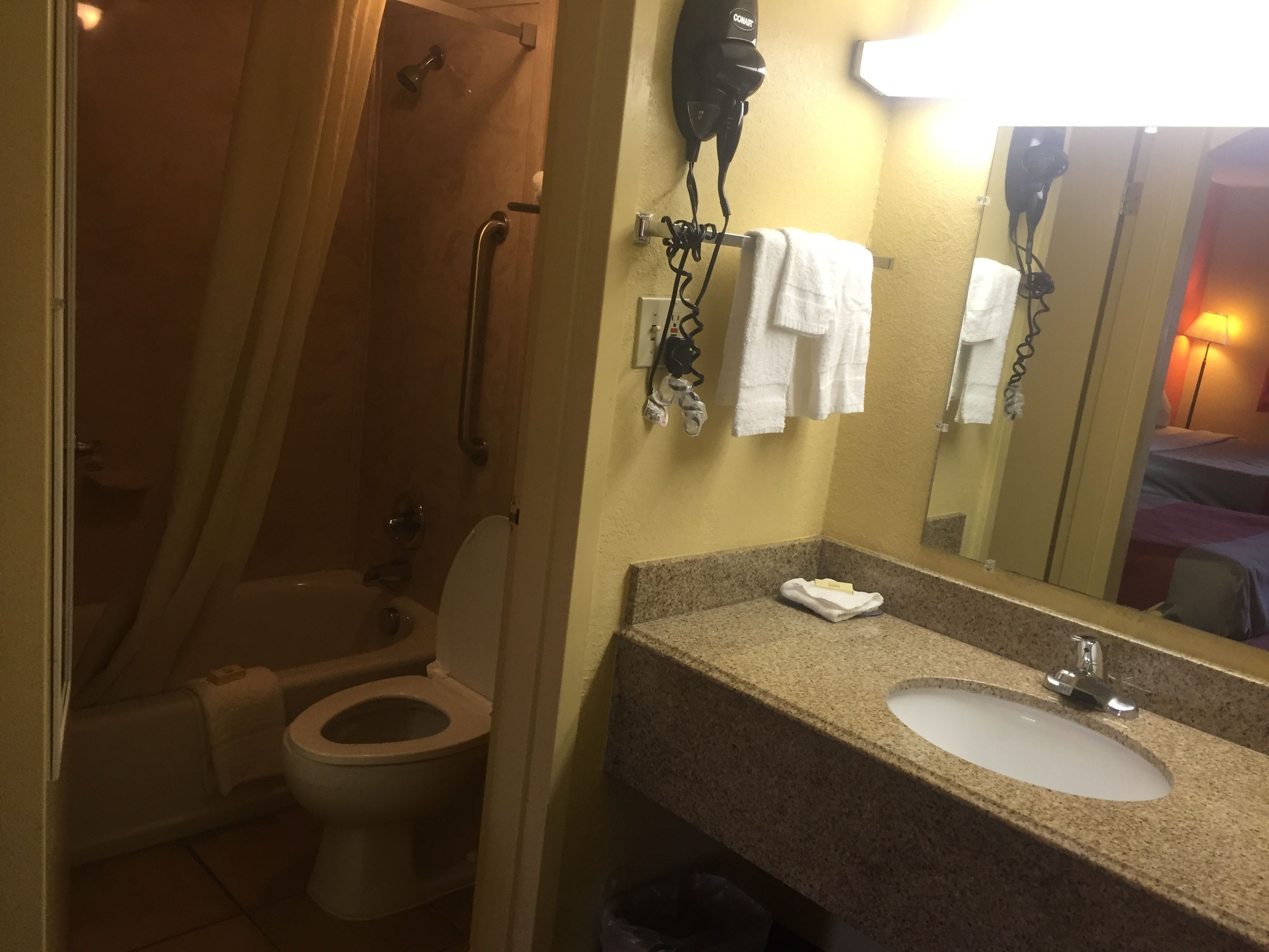 Une salle de bain comprenant des toilettes, un lavabo et un espace douche.