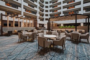 A multi-level hotel lobby with a central seating area, multiple floors, and a modern design.