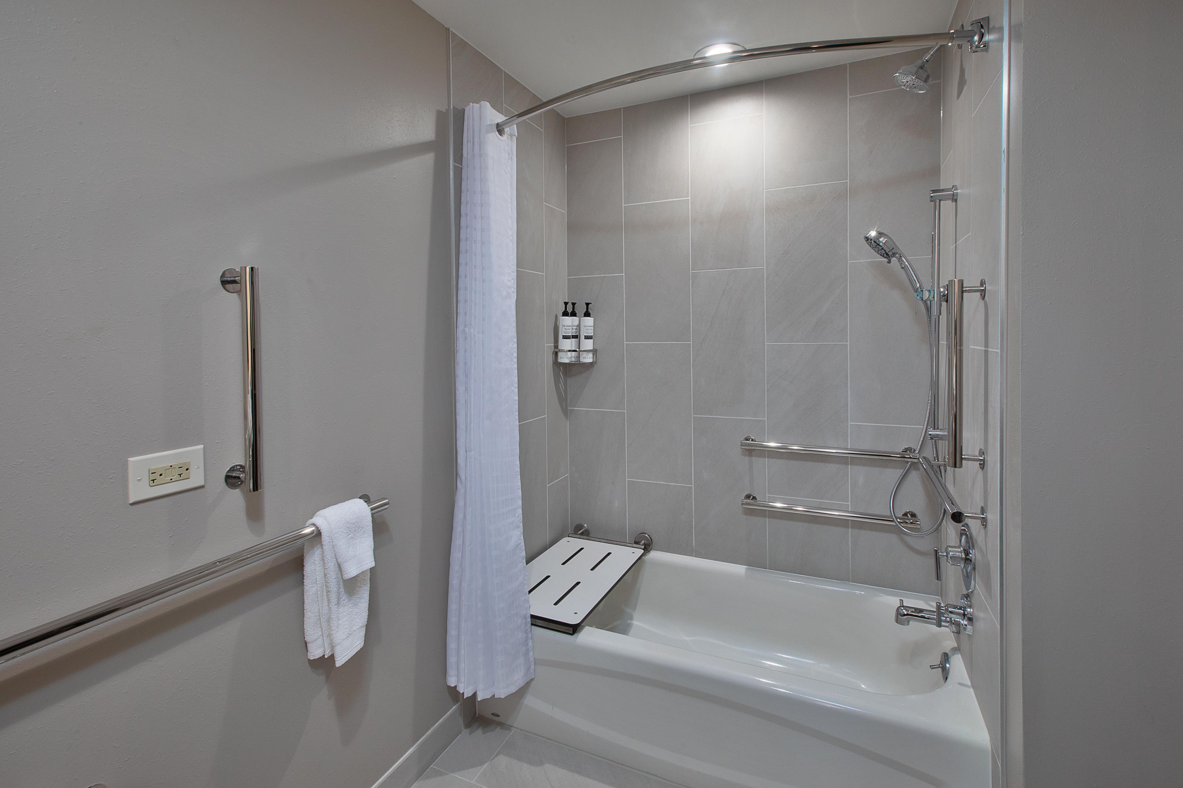 Een moderne badkamer met een inloopdouche, een badkuip en een handdroger.
