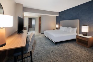 A hotel room with a bed, a desk, a television, and a chair. - Embassy Suites by Hilton Franklin Cool Springs (Franklin)