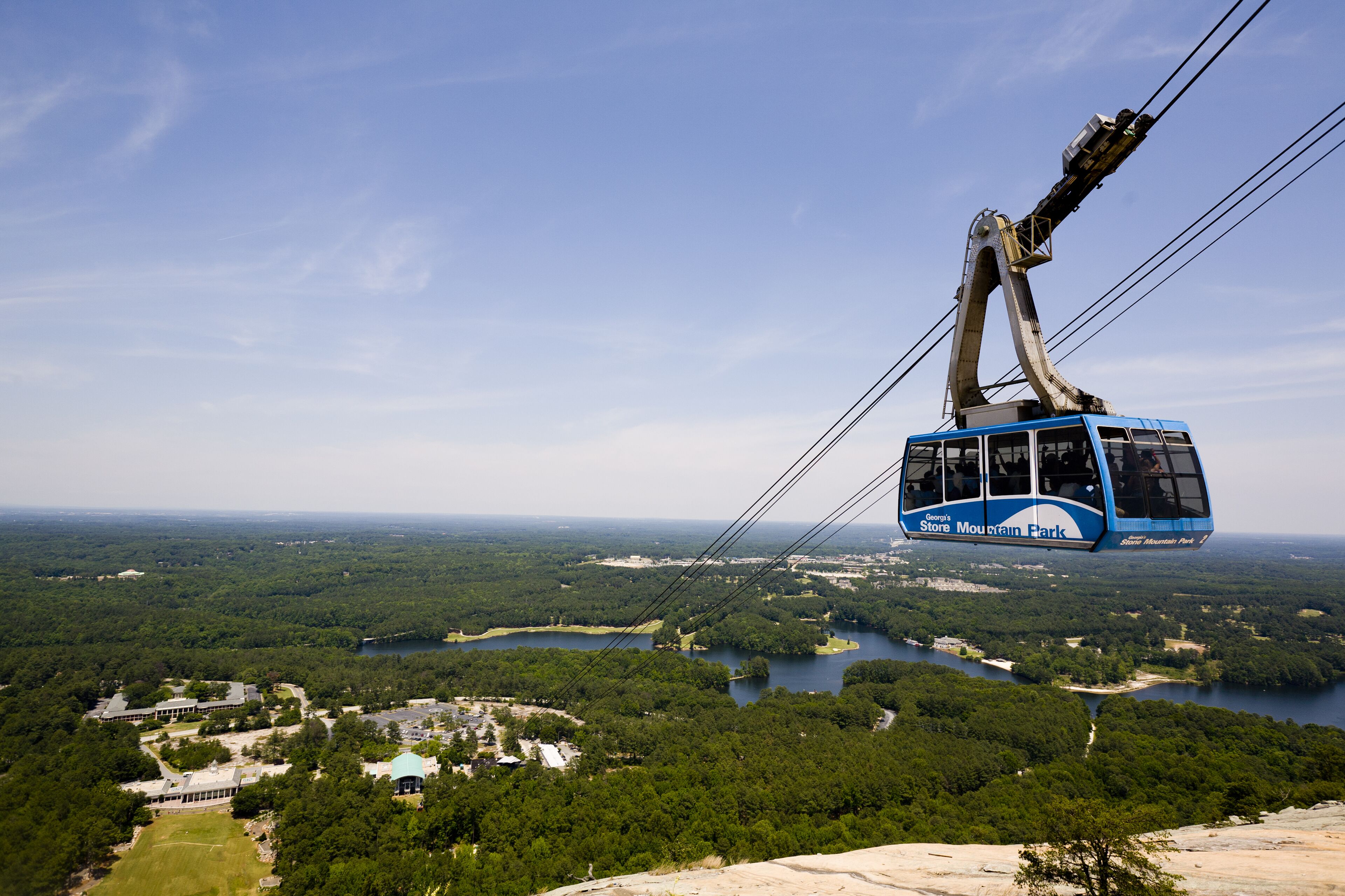 A cable car at a mountain park with views of a lake and forested area.