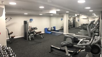 Un gimnasio con cintas de correr, pesas y equipo de ejercicio.