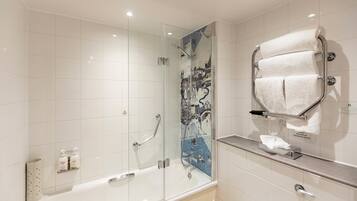 Un bagno moderno con box doccia in vetro, una vasca da bagno e un portasciugamani.