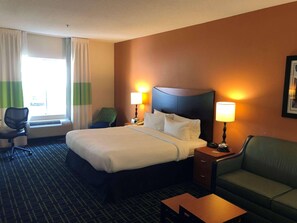 A hotel room with a bed, two bedside lamps, a desk, a chair, a sofa, and a window with curtains. - Country Inn & Suites by Radisson, Fayetteville I-95, NC (Fayetteville)