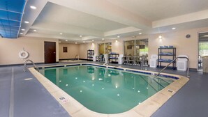 An indoor swimming pool with clear water, surrounded by a blue and beige tiled floor, and equipped with a ladder and a lifebuoy. - Comfort Inn & Suites Hillsville I-77 (Hillsville)