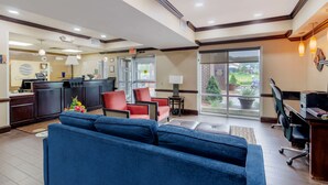 A hotel lobby with a reception desk, seating area, and a view of the outdoors. - Comfort Inn & Suites Hillsville I-77 (Hillsville)