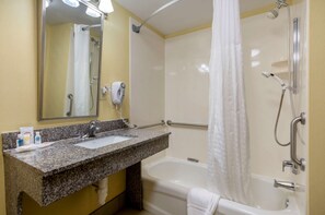 A bathroom with a granite countertop sink, a mirror, a handheld showerhead, and a bathtub. - Comfort Inn & Suites Hillsville I-77 (Hillsville)