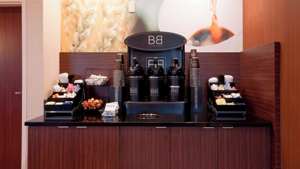 A coffee station with multiple coffee makers and a variety of food items. - Fairfield Inn by Marriott Philadelphia Airport (Philadelphia)